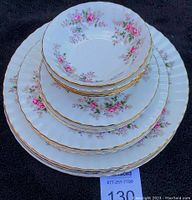 Stacked bowls, bread and butter plates, salad plates, dinner plates showing full set and gold trim