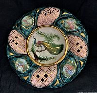 Top view of the porcelain plate showing the peacock center and the surrounding lattice and courting scene medallions