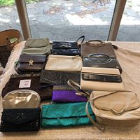 Full display of all 12 vintage purses and clutches on a table in natural light