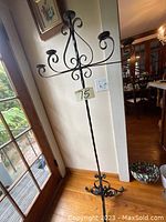 Full view of the antique wrought iron candle stand showing the five candle holders and decorative base.