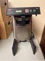 Photo showing front view of Bunn Smart Wave commercial coffee brewer with control panel and cord visible.