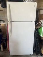 White top freezer refrigerator front view showing full unit closed.