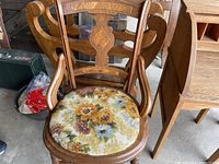 Wooden antique chair with carved backrest and floral fabric seat