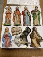 Image showing the hand-painted nativity figurines including the shepherd, three wise men, Mary, baby Jesus, Joseph, and an angel, all inset in styrofoam trays.