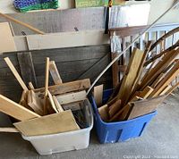 Two plastic bins filled with scrap, craft, and project wood pieces of various sizes and shapes.