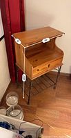 Side view with measurements showing wood tabletop, open storage space, lockable drawer, and metal base with rack shelf.