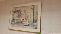 Framed street scene print showing cars, streetcar, and buildings on Toronto King Street with church steeple in background.