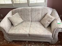 Front view of vintage love seat with two cushions and two loose pillows in patterned fabric.