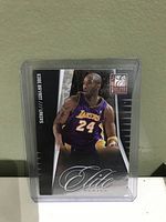 Front view of Kobe Bryant basketball card from Elite Series in protective holder showing player image and name.