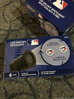Boxed LED Galaxy Spotlights with MLB and Toronto Blue Jays branding, highlighting rotating team logos and plug-in use.