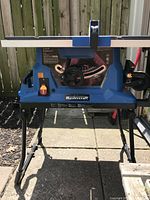 Front angle view showing Mastercraft table saw on foldable metal stand with adjustment controls and blade guard