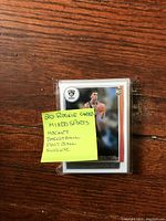 Stack of sealed rookie sports trading cards with sticky note listing 20 cards in hockey, basketball, football, and soccer.