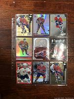 Front view of nine NHL hockey cards in protective binder sleeve, showcasing players primarily from Montreal Canadiens with some holographic and special edition cards