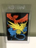 Back side of a Pokémon card showing legendary birds Zapdos, Moltres, and Articuno illustration