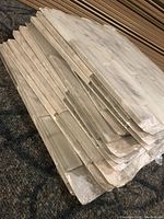 Stack of tile sheets wrapped in plastic showing layers of stone and glass tiles