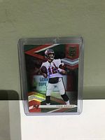 Front of Tom Brady Panini Elite football trading card showing player mid-throw in Buccaneers uniform.