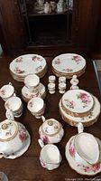 Full assortment on table: plates, cups, saucers, egg cups, salt & pepper shakers, sugar bowl, creamer, teapot with trivet
