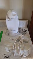 White Toastmaster vertical can opener with classic design, showing brand name and device top with food cutting mechanism.