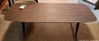 Full top view of the rectangular coffee table with walnut veneer surface, showing its shape and finish.