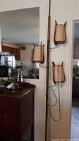 Overall view from left side showing full height and three fabric shades with metal supports attached to tension pole.