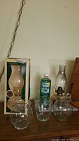 Image showing all items together including vintage oil lamp, three glass vases, Lamplight Farms oil lamp in box, and lamp oil bottle.