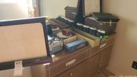 Side view of projector and screen with slide trays and photo albums on table