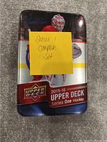 Metal tin for 2015-16 Upper Deck Series 1 Hockey complete card set with a sticky note stating 'Series 1 complete set'.
