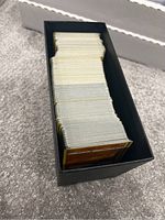 Top-down view inside a black ETB box showing a large amount of Pokémon cards from Battle Styles set stacked neatly.