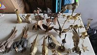 Overall assortment of metal figurines and decorative objects on table