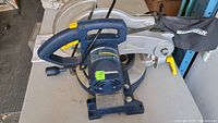 Side view of the Mastercraft 10-inch miter saw showing blue handle, motor, and base.