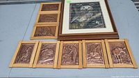 Full lot overview showing the framed 3D owl picture and set of 8 smaller copper molded picture panels all on a flat surface.