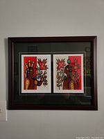 Front view of the framed art print featuring two Ojibwa-themed prints by Christian Morrisseau under glass in a wooden frame with dark green matting.