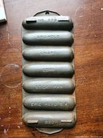 Top-down view of antique Griswold cast iron cornbread stick pan showing embossed text and condition.