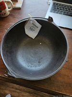 Top view of the cast iron bowl showing interior and identification tag