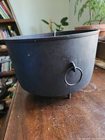 Side view of the antique ERIE cast iron cauldron showing ring handle and tripod legs