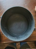 Top-down view of the empty interior of the round cast iron pot, showing condition inside.