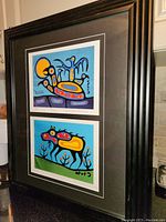 Photo of the framed double print artwork showing the full frame and matting with the two colorful prints inside.