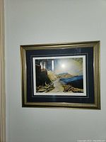 Framed and matted fine art print showing a coastal landscape with driftwood, cliffs, and mountains under a curved sky, taken from straight on.