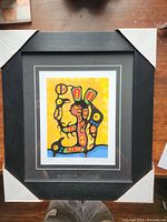 Full view of framed and matted Morrisseau print titled "Chino" with protective corner guards on frame edges.