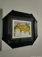 Framed print front view showing artwork, matting, and frame with protective corner covers still on.