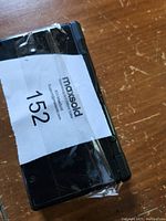 Black Nintendo DS Lite handheld console with MaxSold auction tag taped on top.