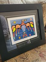 Angled photo of the framed print showing the full artwork, frame, and surrounding environment.