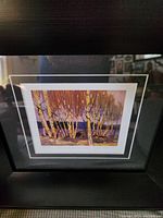 Close-up of the framed print showing the landscape with birch trees and lake, matted with white borders.