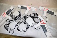 Two complete sets of Laser X laser tag guns and sensor vest gear on white surface