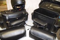 Two saddlebags set open on floor with detachable pouches and helmet perched on one bag