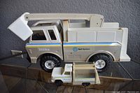 Front view of the large and small Tonka Bell System toy trucks showing side profile