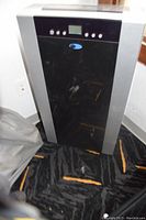 Front view of the portable air conditioner showing black control panel with blue logo and digital display