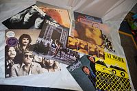 Overview of all vintage vinyl record albums from various rock groups arranged on a white surface