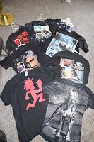 Seven graphic T-shirts laid out together showing front designs