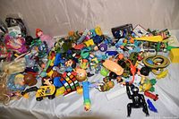 Wide view of tub filled with a large assortment of small toys, including action figures, Pez dispensers, and various plastic characters